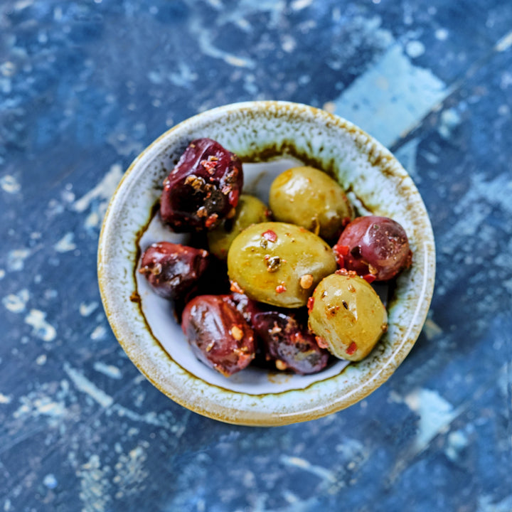 Grønne og sorte græske oliven i olivenolie og krydderier fra Oliviers & Co